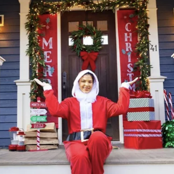 Girl in Santa outfit at decorated front door