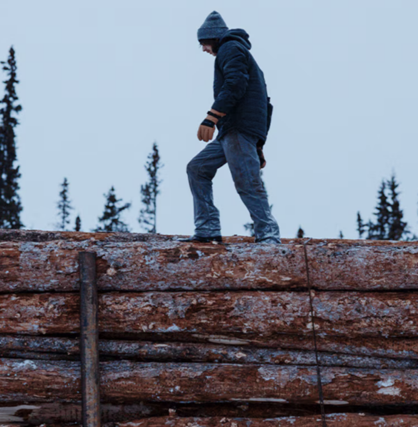 Man walking on top of logs