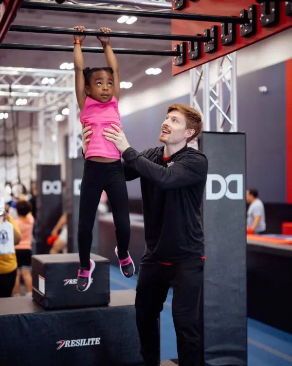 Coach helping little girl